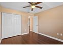 This bedroom features a ceiling fan, wood floors, a closet, and neutral walls, creating a cozy and inviting atmosphere at 1430 17Th St, Orange City, FL 32763