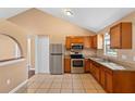 Well-lit kitchen featuring stainless steel appliances, wooden cabinets, tile flooring, and a pantry with easy access to the dining area at 1430 17Th St, Orange City, FL 32763