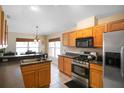 Efficient kitchen design with stainless steel appliances, wooden cabinets, and adjacent dining area at 1458 Ashbourne Way, Deltona, FL 32725