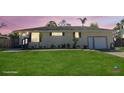 Charming single-story home with a well-manicured front lawn and an attached two-car garage at 1551 7Th Ave, Deland, FL 32724