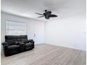 A cozy living room with wood floors, ceiling fan and a comfortable black reclining sofa set at 1767 Valencia Ave, Ormond Beach, FL 32174