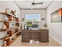 Office with built-in shelves, a large desk, ceiling fan and natural light from a window at 3329 Bailey Ann Dr, Ormond Beach, FL 32174