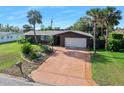 Inviting single-story home with a long driveway, mature landscaping and a well-manicured front lawn at 354 Georgetown Dr, Daytona Beach, FL 32118