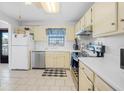 Well-lit kitchen featuring white cabinetry, appliances, and tile flooring at 3620 Cardinal Blvd # 80, Daytona Beach, FL 32118