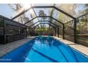 Clear blue pool surrounded by a screened enclosure, providing a private and refreshing outdoor retreat at 464 Nash Ln, Port Orange, FL 32127
