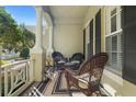 Charming front porch with rocking chairs, striped rug, and decorative plants, perfect for relaxation at 509 Victoria Hills Dr, Deland, FL 32724