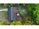 Aerial shot showcasing a backyard deck with outdoor seating surrounded by lush trees at 514 Land O Lakes Ct, Deland, FL 32724