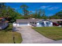 Nice view of the one-story home with a long driveway, large yard, and nice landscaping at 538 Gertrude Ln, South Daytona, FL 32119