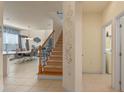 Inviting entryway with staircase, decorative wall accents, and views of the dining and living areas at 544 Red Rose Ln, Sanford, FL 32771