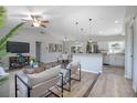 Bright, open living room with vaulted ceilings and wood-look floors flowing into the kitchen and dining area at 597 Gainsboro St, Deltona, FL 32725