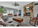 Spacious living room features a brick fireplace, ceiling fan, and wood look floors at 725 Briarcrest Dr, Orange City, FL 32763