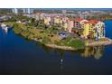 An aerial view shows waterfront condominiums, surrounded by water and lush landscaping at 732 Marina Point Dr # 7320, Daytona Beach, FL 32114