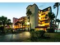 Exterior shot of a multi-story condominium building, featuring palm trees and evening illumination at 732 Marina Point Dr # 7320, Daytona Beach, FL 32114