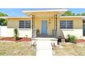 Inviting front porch with decorative iron railings, a vibrant blue door, and lush landscaping adding curb appeal at 10 Lilac Dr, Debary, FL 32713