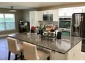 Open kitchen with stone countertops, stainless appliances, white cabinets and counter seating at 112 Grande Lake Dr, Daytona Beach, FL 32124
