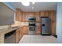 Bright kitchen with stainless steel appliances, wooden cabinets, and granite countertops at 120 Black Duck Cir, Daytona Beach, FL 32119
