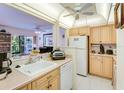 Open kitchen with ample counter space, light wood cabinets and bright lighting at 120 Hibiscus Woods Ct # 14D, Deltona, FL 32725
