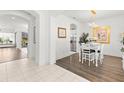 Open-concept dining area with wood floors, white furniture, and access to kitchen at 1205 Draycott St, Ormond Beach, FL 32174