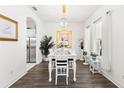 Formal dining room with wood floors, bright white walls, and elegant chandelier at 1205 Draycott St, Ormond Beach, FL 32174