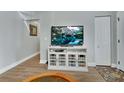 Living room features a television with a white cabinet and stylish wood-look flooring at 1434 Deltona Blvd, Deltona, FL 32725