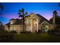 Elegant two-story home at dusk, boasting lush greenery and a beautifully illuminated facade at 1450 Shady Meadow Ln, Deland, FL 32724