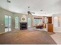 Spacious living room featuring carpet, a fireplace, and large windows with natural light at 1490 Kettledrum Trl, Enterprise, FL 32725