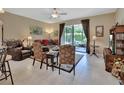 Inviting living room featuring a ceiling fan, sliding glass doors and neutral tile flooring at 1512 Lancashire Way, Deland, FL 32720
