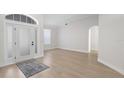 Bright foyer with a glass-paned front door, light hardwood floors, neutral walls, and an arched doorway at 1540 Park Forest Blvd, Mount Dora, FL 32757