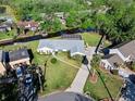Aerial view of a single-story home with screened in pool on a canal with boat dock at 19 Twin River Dr, Ormond Beach, FL 32174
