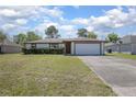 Charming single-story home with a well-manicured lawn and attached two-car garage at 2017 Monterey Dr, Deltona, FL 32738