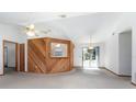 Bright living room featuring a ceiling fan, and unique wood paneled breakfast bar to the kitchen at 2017 Monterey Dr, Deltona, FL 32738