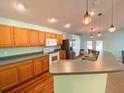 Well-equipped kitchen features stainless steel appliances, wood cabinetry, and an extended counter for casual dining and food preparation at 209 Oak Branch Drive, Edgewater, FL 32141