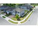 Aerial view of a gray home situated on a corner lot, featuring a well-kept lawn and brick driveway at 2090 Prairie Sage Ln, Longwood, FL 32750