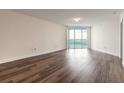 Spacious living room featuring beautiful hardwood floors and sliding glass doors to a balcony with a water view at 231 Riverside Dr # 1003-1, Daytona Beach, FL 32117