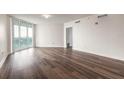 Bright and airy living room features hardwood floors and large sliding glass doors to a balcony with a city view at 231 Riverside Dr # 1003-1, Daytona Beach, FL 32117