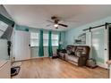 Cozy living room featuring wood-look flooring, a ceiling fan, and comfortable leather sofa at 28 River Dr, Ormond Beach, FL 32176