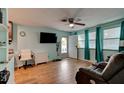 Bright living room with wood-look tile flooring, ceiling fan, and comfortable seating at 28 River Dr, Ormond Beach, FL 32176