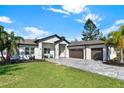Beautiful home featuring three car garage, front sitting area, and stone paver driveway at 29127 Old E Ml, Tavares, FL 32778