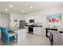 Modern kitchen with white cabinets, granite countertops, stainless steel appliances, and a kitchen island with seating at 3075 Meleto Blvd, New Smyrna Beach, FL 32168