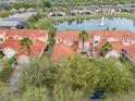 Aerial view of community featuring red-tiled roofs and a scenic pond with a fountain at 3145 Connemara Dr, Ormond Beach, FL 32174