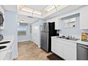 Bright kitchen featuring stainless steel appliances, white cabinets, and tile floors at 3333 S Atlantic Ave # 2202, Daytona Beach, FL 32118