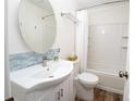 Cozy bathroom with a sink, toilet, vanity, round mirror, and shower-tub combo with new tiled walls at 511 Powers Ave, Port Orange, FL 32127