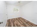 Bright bedroom with hardwood flooring, white walls, ceiling fan, and plenty of natural light from shuttered windows at 511 Powers Ave, Port Orange, FL 32127