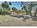 Home featuring an open yard, mature trees and landscaping, and neutral exterior paint at 530 Taylor Dr, Orange City, FL 32763