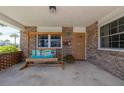 Relaxing front porch with a swing, brick accents, and a charming front door at 7 Kathy Dr, Ormond Beach, FL 32176