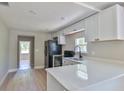 Well-equipped kitchen boasts white cabinets, stainless steel appliances, and a breakfast bar at 709 Cedar St, Daytona Beach, FL 32114