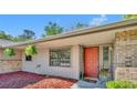 Close-up of the front entrance with a brightly colored door, brick accents, and attractive plants at 715 Oak Ter, Orange City, FL 32763