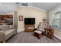 Comfortable living room featuring a flat screen tv, sitting area, and open view of kitchen at 7462 Se 172Nd Fieldcrest St, The Villages, FL 32162