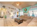 Open living room with turquoise accent wall, tile floor, and access to other rooms at 811 Smokerise Blvd, Port Orange, FL 32127