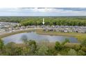 Aerial view of a neighborhood featuring a community lake surrounded by lush trees at 9033 Cape Cod Rd, Deland, FL 32724
